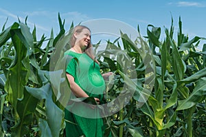 Pregnant woman stand at the corn field