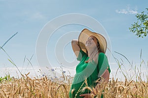 Pregnant woman stand at the wheat field