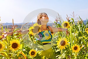Pregnant woman standing on field sunflowers