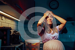 Pregnant Woman Standing in the Kitchen Remembering Something