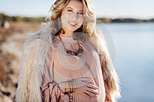 Pregnant woman standing near the river while walking