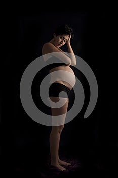 Pregnant woman standing over black