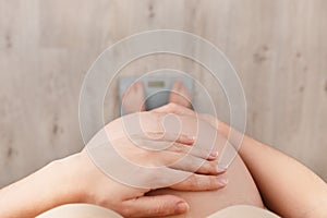 Pregnant woman standing on scales