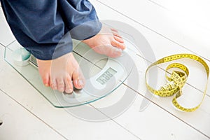 Pregnant woman standing on scales to control weight gain