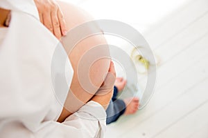 Pregnant woman standing on scales to control weight gain