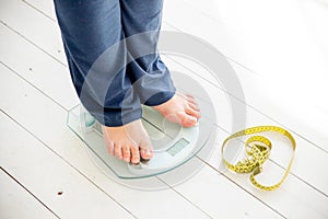 Pregnant woman standing on scales to control weight gain