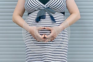Pregnant woman standing on striped background