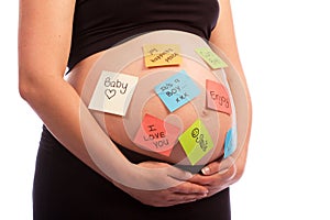 Pregnant woman with sticky notes on belly