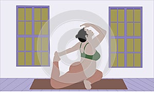 Pregnant woman stretches the entire body doing Pigeon pose in the studio room on a yoga mate. Relaxation and exercises in