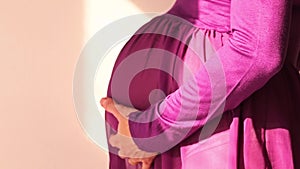 Pregnant woman stroking her belly with her hands