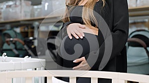 pregnant woman stroking her belly at the supermarket