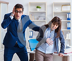 Pregnant woman struggling in the office and getting colleague he