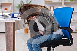 The pregnant woman struggling with pain in office