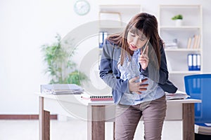 The pregnant woman struggling to do work in office