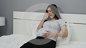 Pregnant woman stuffy nose, sneezing, sore throat on bed. flu during pregnancy