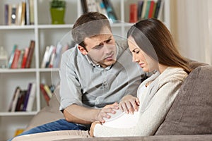 Pregnant woman suffering and husband comforting her