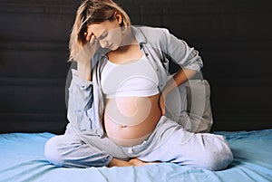 Pregnant woman suffering lower back pain or headache