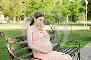 Pregnant woman suffering from toxicosis in the park