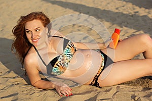 Pregnant woman sunbathing on the beach