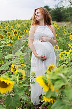 Pregnant woman in sunflowers field