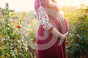 Pregnant woman in sunny field