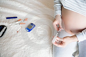 Pregnant woman with syringe, diabetes at home concept.