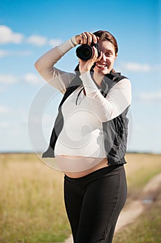 Pregnant woman taking photo with camera