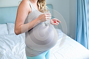 Pregnant woman taking a pill