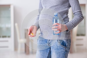 The pregnant woman taking pills during pregnancy