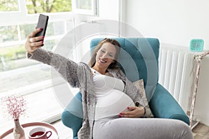 Pregnant woman taking selfies