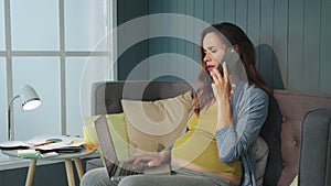 Pregnant woman talking on phone at home. Closeup belly mother working laptop