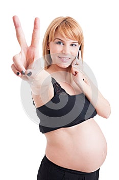 Pregnant woman talking on phone and showing peace or victory