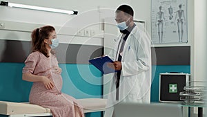 Pregnant woman talking to doctor about pregnancy
