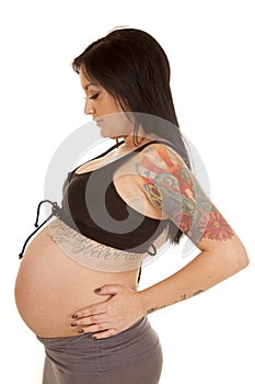 Pregnant woman tattoos show belly side look down