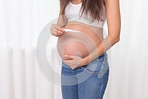 Pregnant woman with a thermometer in her bedroom. Pregnancy health and medcine contest. Illness, cold, flu, allergy. Covid photo