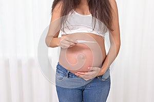 Pregnant woman with a thermometer in her bedroom. Pregnancy health and medcine contest. Illness, cold, flu, allergy. Covid-19 photo