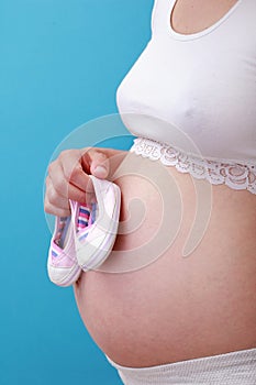 Pregnant woman with tiny shoes