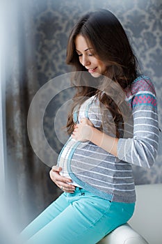 Pregnant woman touching hands big belly