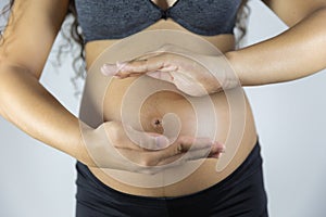 Pregnant woman touching her belly.