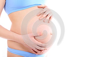 Pregnant woman touching her belly with hands