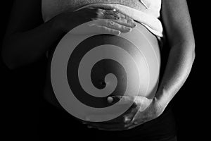 Pregnant woman touching her belly with hands