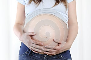 Pregnant woman touching her belly with hands, Close up