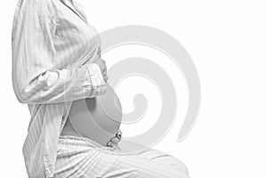 Pregnant woman touching her belly with hands isolated on white