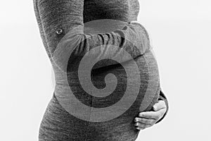 Pregnant woman touching her belly with hands, on white background