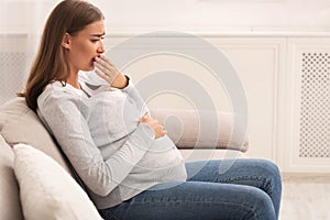 Pregnant Woman Touching Mouth Feeling Sick Sitting On Couch Indoor