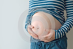 Pregnant woman touching and rubbing her belly