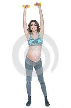 Pregnant woman training with dumbbells to stay active. Pregnant woman practicing fitness and working out during