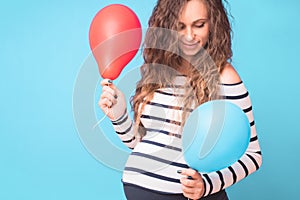 Pregnant woman tries to guess the boy or girl. Balloons as symbol of boy and girl.