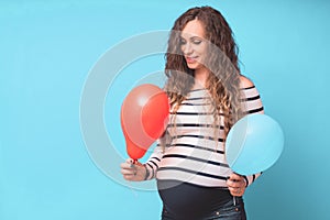 Pregnant woman tries to guess the boy or girl. Balloons as symbol of boy and girl.