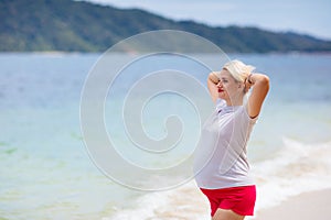 Pregnant woman on tropical beach holiday